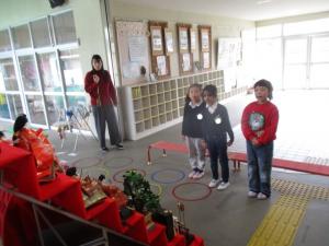 ひな壇の前で歌をうたう子ども