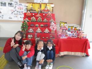 ひな壇の前で写真を撮る子どもと先生