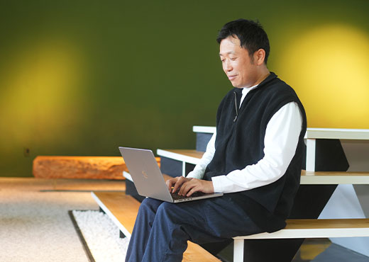 ノートパソコンで仕事をする金さん