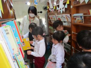 「あおぞら号」の車内で絵本を選んでいます。