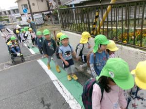 ２組とひまわり組が手をつないで歩いています