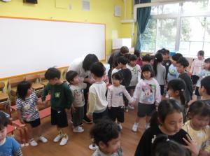 3歳児を誘って手をつなぐ年長児