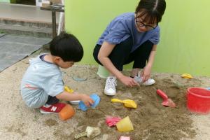 親子で砂の型抜きをして遊んでいる