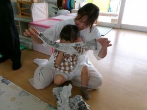 新聞紙を破る親子