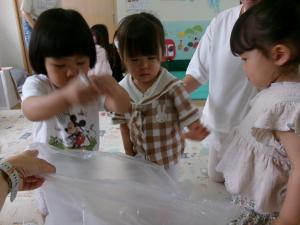 新聞紙を袋に入れる子ども