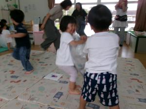 新聞紙をいれた袋で遊ぶ子ども