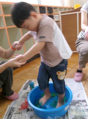 寒天の入ったたらいを踏んで感触を楽しむ子ども