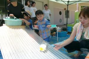 波板に氷を転がす子ども