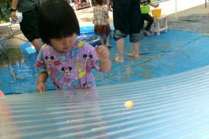 波板にスーパーボールを転がす子ども
