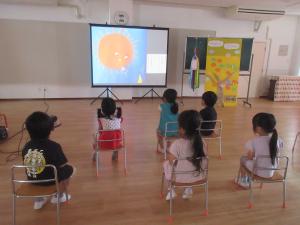 スライドでの絵本の読み聞かせを聞いています