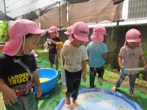 3人の子どもが噴水に入っています。