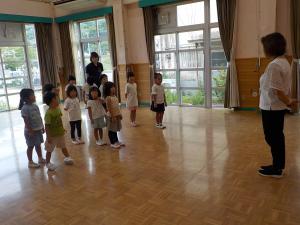 園長先生の話を聞く子ども