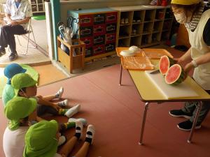 スイカの断面を見ている子ども