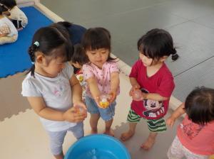 丸い氷を見せる子ども