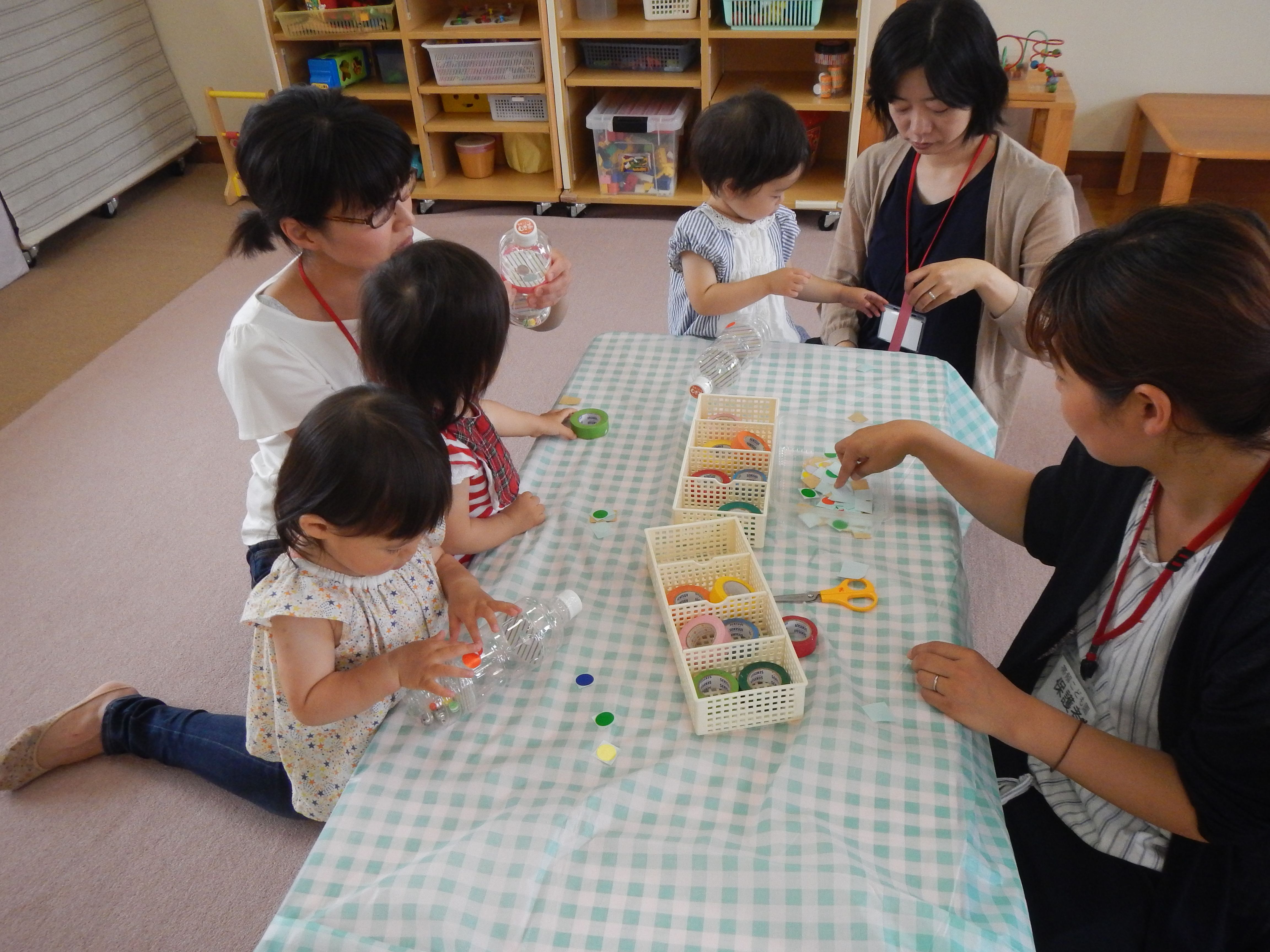 ビーズやスズをペットボトルに入れておもちゃをつくっている