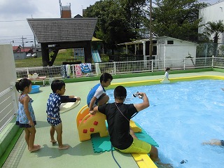 プールで滑り台を滑る子どもたちの画像1