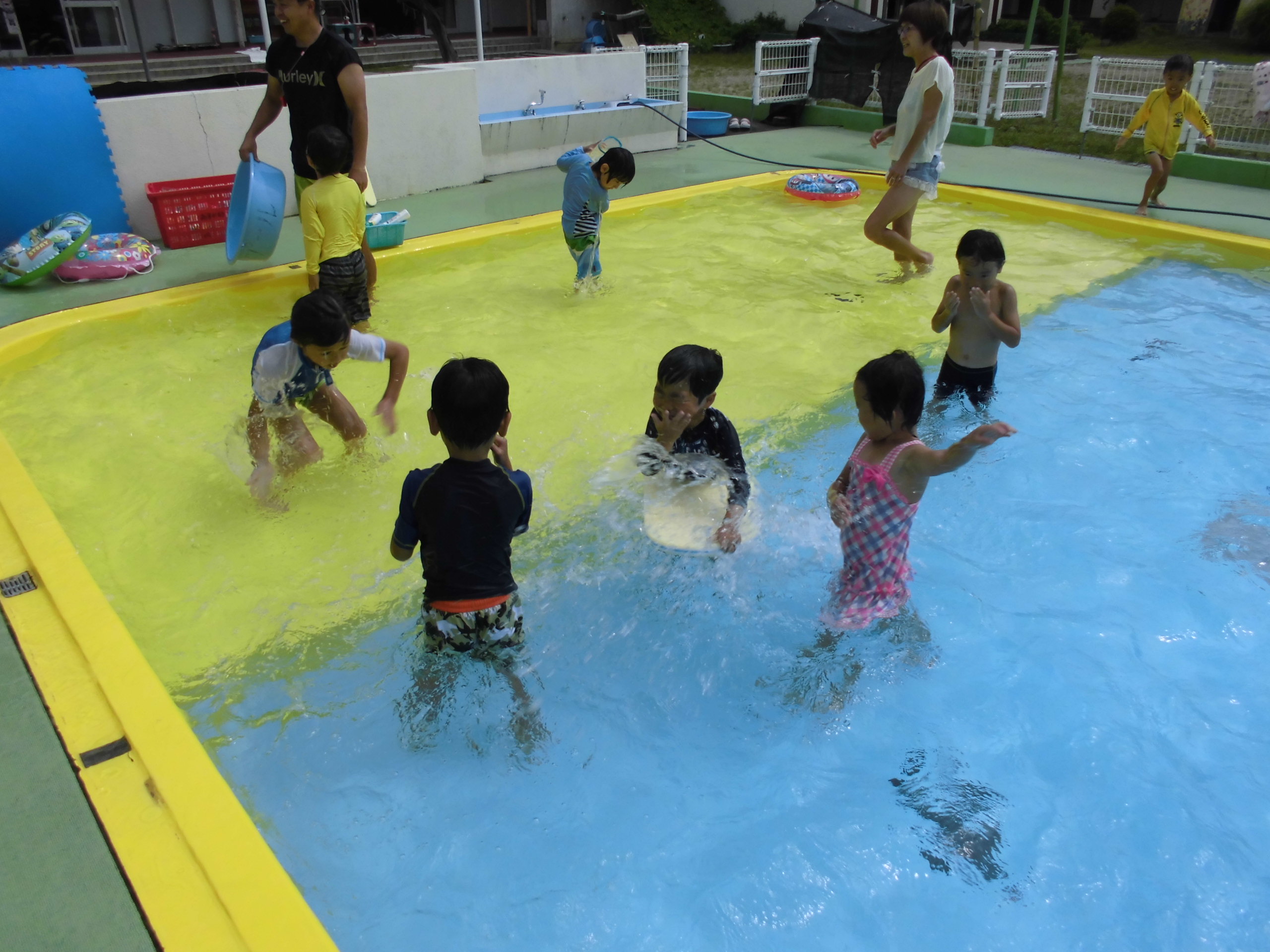 プールで水のかけあいっこをする子どもたちの画像6