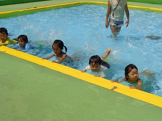 プールでバタ足をする4歳児