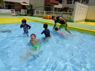 プールで泳ぐ練習をする5歳児