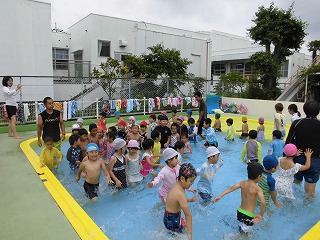 体育講師の指導のもとプールの中を歩く子どもたち