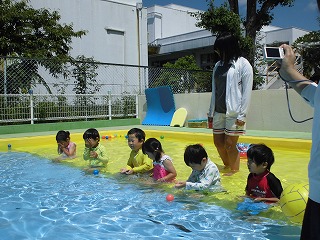 プールで顔に水をかける4歳児