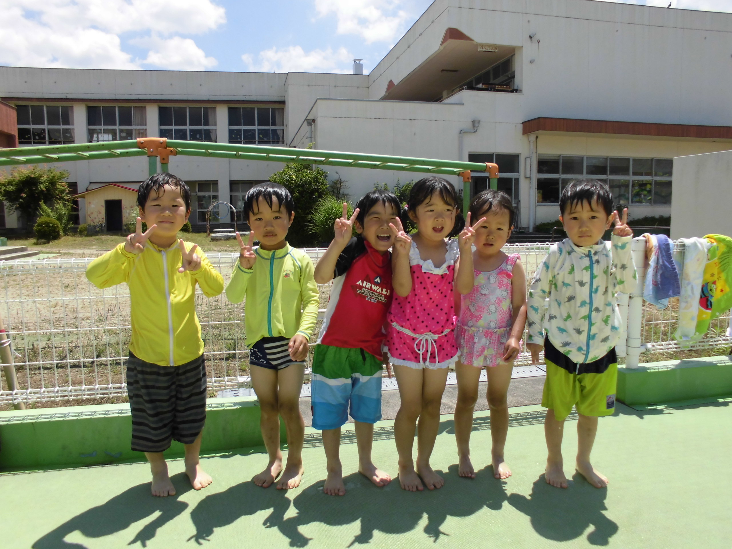 プールサイドでポーズをとる4歳児