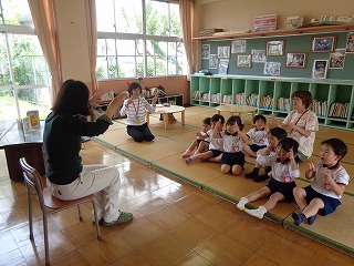 お話の会で手遊びをする4歳児