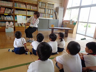 お話の会で絵本を見る5歳児