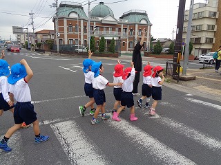 手をあげて横断歩道を渡る子どもたち