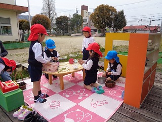 ログハウスでままごと遊びをする子どもたち