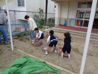 砂場の玩具を運ぶ5歳児の画像1
