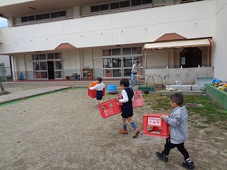 砂場の玩具を運ぶ5歳児の画像2