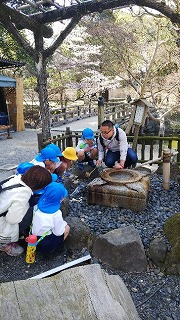 水琴窟で不思議な水の音を聴く5歳児