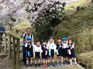 桜をバックにポーズをとる5歳児